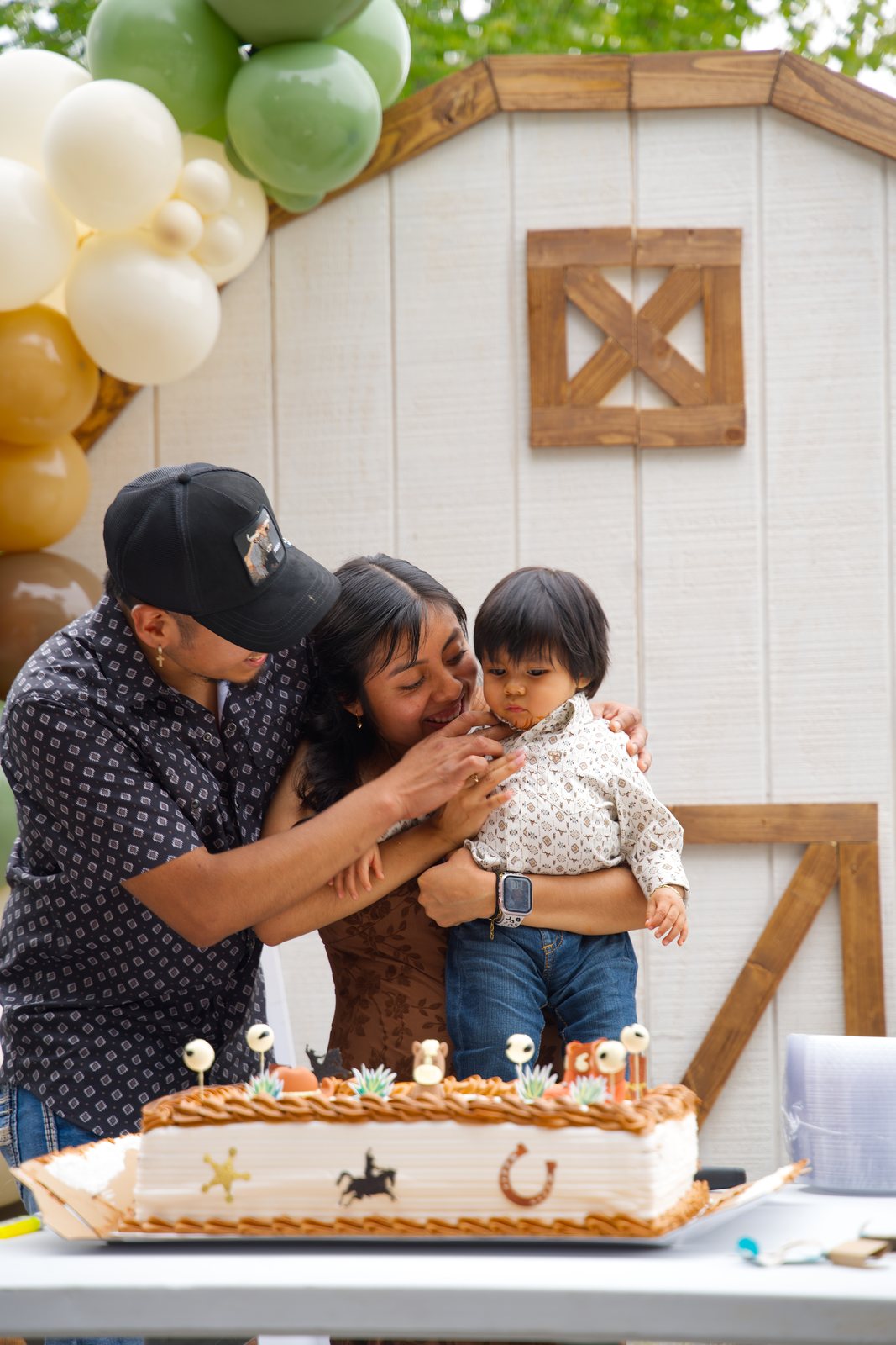 Parents with their son at his first birthday cake